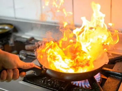 Bărbat gătind în tigaie, la aragaz cu gaze - Foto: Pexels/Christopher Welsch Leveroni
