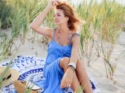 Tânără femeie relaxându-se pe plajă - Foto: Freepik/svetlanasokolova