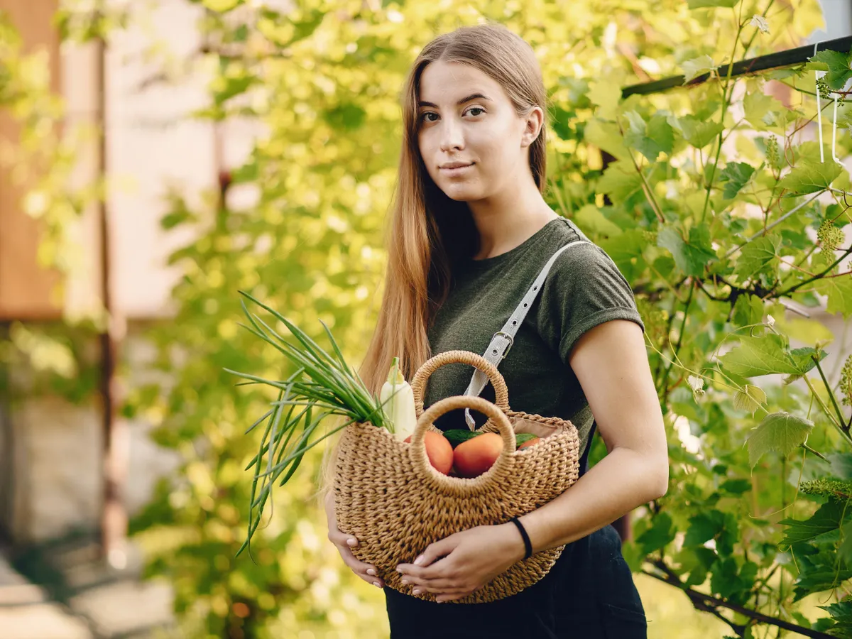 O femeie frumoasă lucrează într-o grădină lângă casă - Foto: Magnific.com (Imagine cu rol ilustrativ)