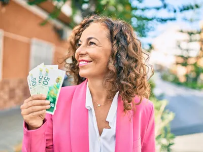 Femeie cu bani în mână - Foto: Freepik (rol ilustrativ)