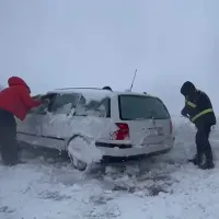 Poliţişti dezzăpezind o maşină blocată în nămeţi, în Botoşani - Foto: captură video Monitorul de Botoşani