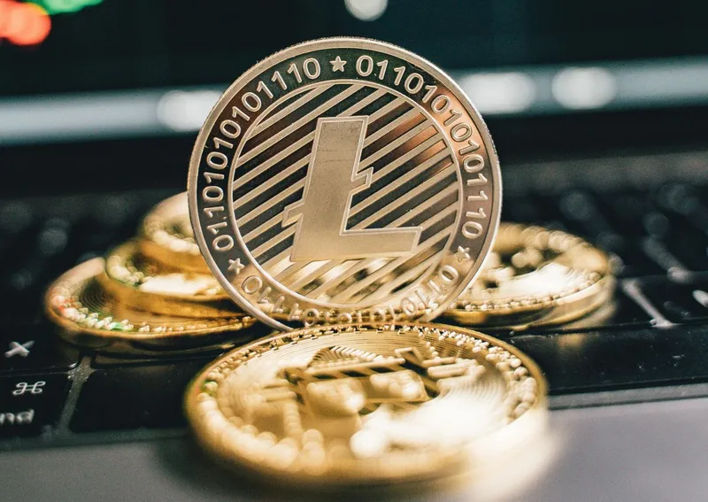 Monede de aur pe keyboard-ul unui laptop - Foto: Pexels/Alesia Kozik