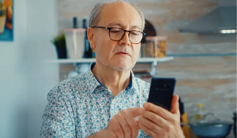 Batrânul citește un mesaj pe whatsapp - Foto: Freepik