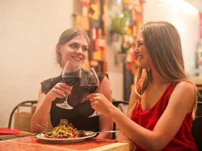 Două femei la restaurant ciocnesc un pahar de vin - Foto: Pexels/Andrea Piacquadio