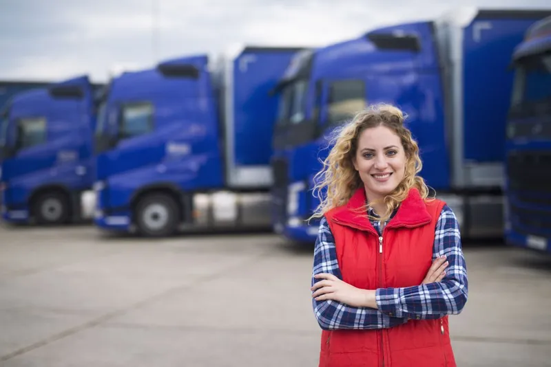 Şoferiţă de camion poz&acirc;nd &icirc;n faţa vehiculelor - Foto: Magnific.com/aleksandarlittlewolf