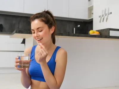 Femeie care are o capsulă cu vitamine în mână - Foto: Freepik (rol ilustrativ)