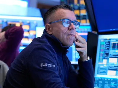 Trader de pe Wall Street, de la NYSE, urmărind evoluţia indicilor bursieri - Foto: Profimedia Images