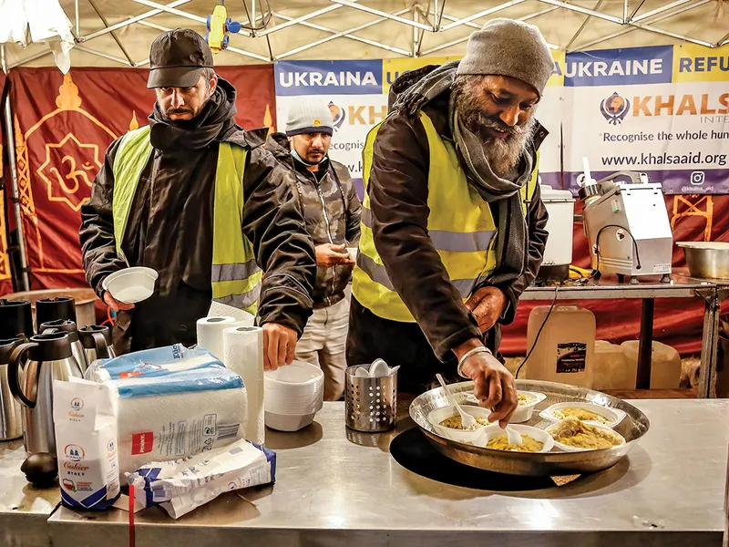 Voluntarii oferă băuturi și gustări într-o tabără temporară pentru refugiații ucraineni din Przemisl, Polonia