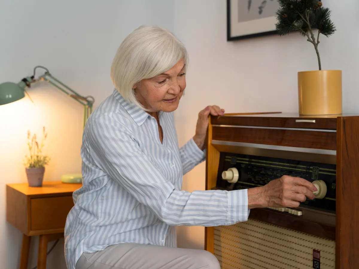 Pensionar deschizând radioul - Foto: Freepik