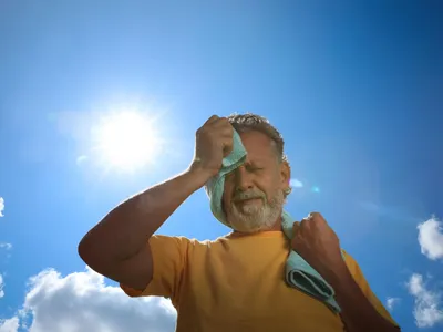 Bărbat senior cu prosop care suferă de insolație în aer liber - Foto: Magnific.com (Imagine cu rol ilustrativ)