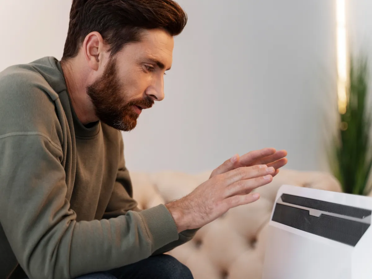 Bărbat care se încălzește la o aerotermă - Foto: Freepik (Imagine cu rol ilustrativ)