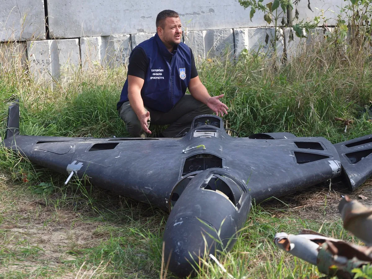 Un angajat al Procuraturii Regionale Harkov din Ucraina stă în genunchi lângă un fragment al unui drone Shahed găsit la locul unui atac rus în Harkov, Ucraina, pe 19 septembrie 2025 - Foto: Profimedia Images