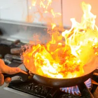 Bărbat gătind în tigaie, la aragaz cu gaze - Foto: Pexels/Christopher Welsch Leveroni