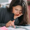 Femeie frumoasă calculându-şi impozitul pe venit - Foto: Magnific.com/teksomolika