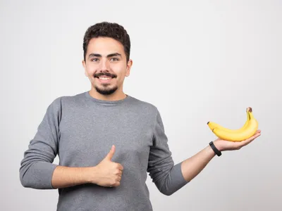 Bărbat cu banane în mână - Foto: Magnific.com (Imagine cu rol ilustrativ)