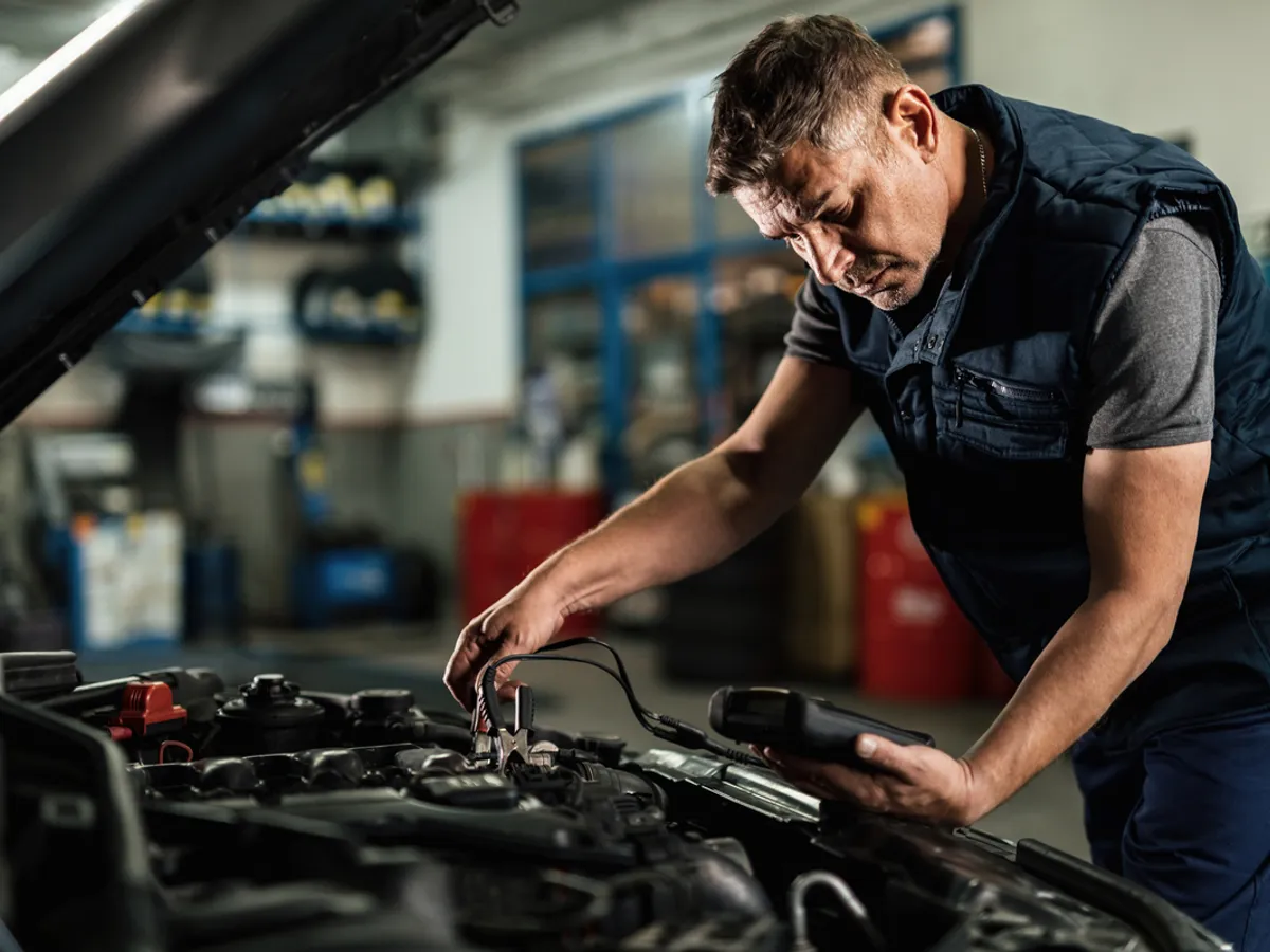 Un electrician auto verifică nivelul de încărcare al alternatorului - Foto: magnific.com