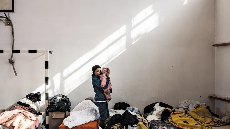 O mamă își leagănă copilul la un adăpost temporar pentru refugiați din Ungaria