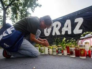 O femeie aprinde o lumânare în amintirea victimelor atacului de la Graz - Foto: Profimedia Images