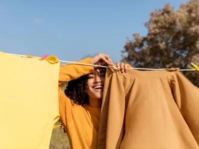 Persoană vare usucă rufe afară tomna - Foto: Freepik (Imagine cu rol ilustrativ)