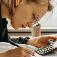 Femeie făcând calcule complicate - Foto: Pexels/Mikhail Nilov