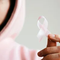 Femeie purtând o panglică roz, simbolul suferinzilor de cancer - Foto: Pexels/Anna Shvets