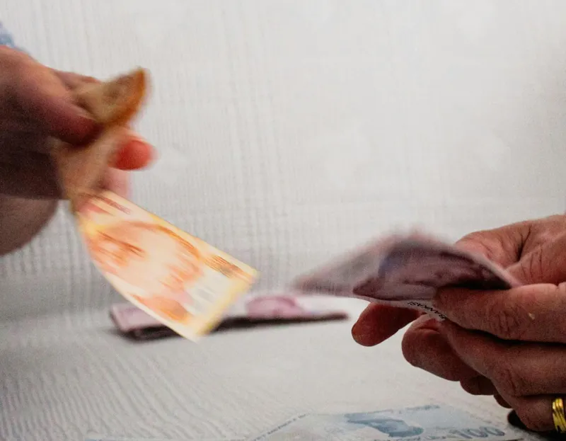 M&acirc;ini schimb&acirc;nd bani, pe o sofa albă - Foto: Pexels/Şevval &Ccedil;adır