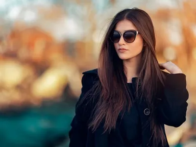 Femeie purtând ochelari de soare damă, model elegant cu lentile închise, accesoriu care completează ținuta și oferă protecție UV în zilele însorite - Foto: Pexels