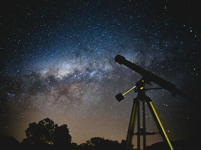 Telescop negru, pe fundalul unui cer albastru-alburiu, noaptea - Foto: Pexels/Lucas Pezeta