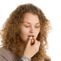 Tânără femei luându-şi medicamentele compensate - Foto: Freepik/yanalya