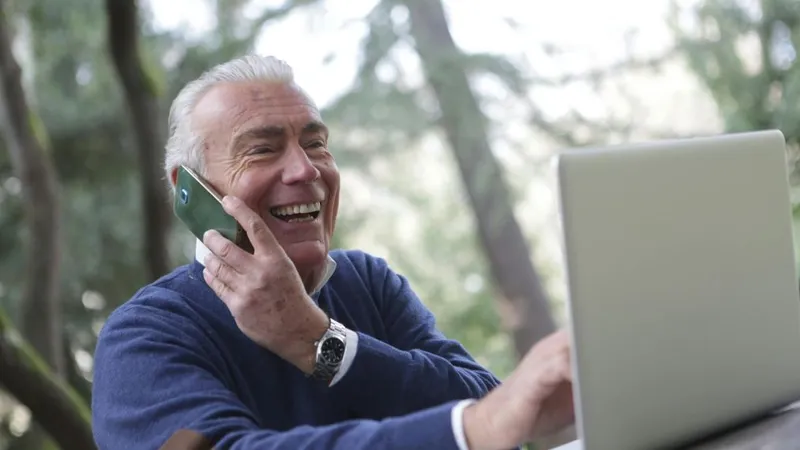 Bărbat în etate vorbind la telefon şi, simultan, navigând pe Internet - Foto: Pexels/Andrea Piacquadio