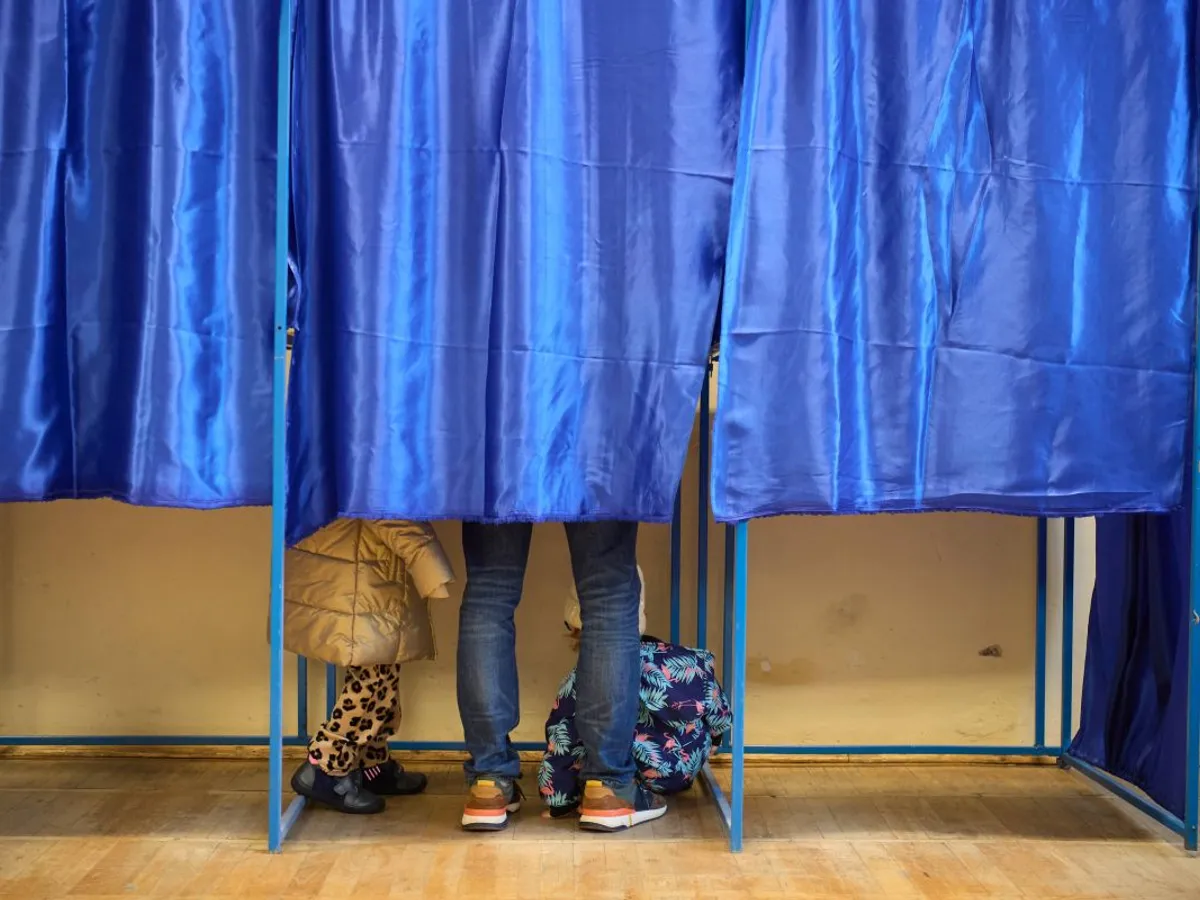 Votant în cabina de vot, care şi-a adus cu el şi copilul - Foto: INQUAM PHOTOS/Codrin Unici