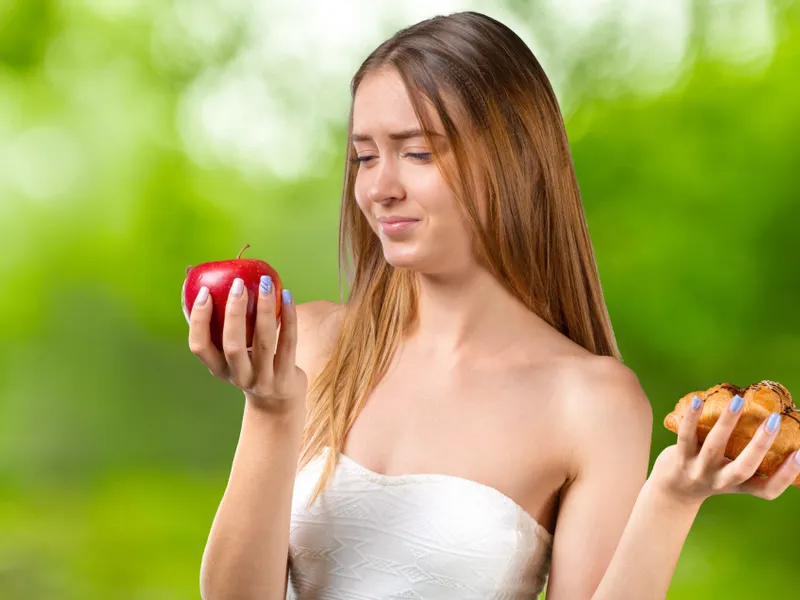 O femeie frumoasă care are în mână o piersică - Foto: Freepik