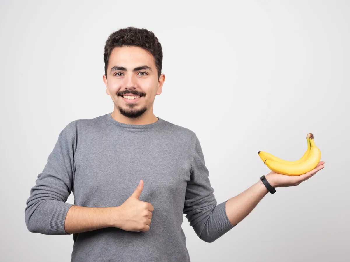 Bărbat cu banane în mână - Foto: Magnific.com (Imagine cu rol ilustrativ)