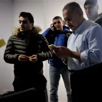 Kamil Demirkaya, în stânga imaginii, cu un telefon în mână Foto: zaman România