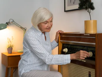 Pensionar deschizând radioul - Foto: Freepik