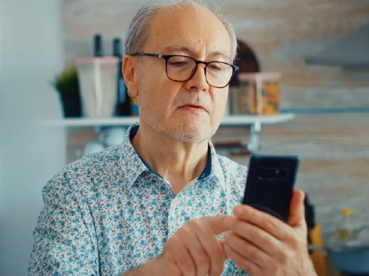 Batrânul citește un mesaj pe whatsapp - Foto: Freepik