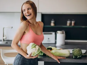 Femeie la bucătărie, pregătindu-se să gătească legume - Foto: Freepik/senivpetro