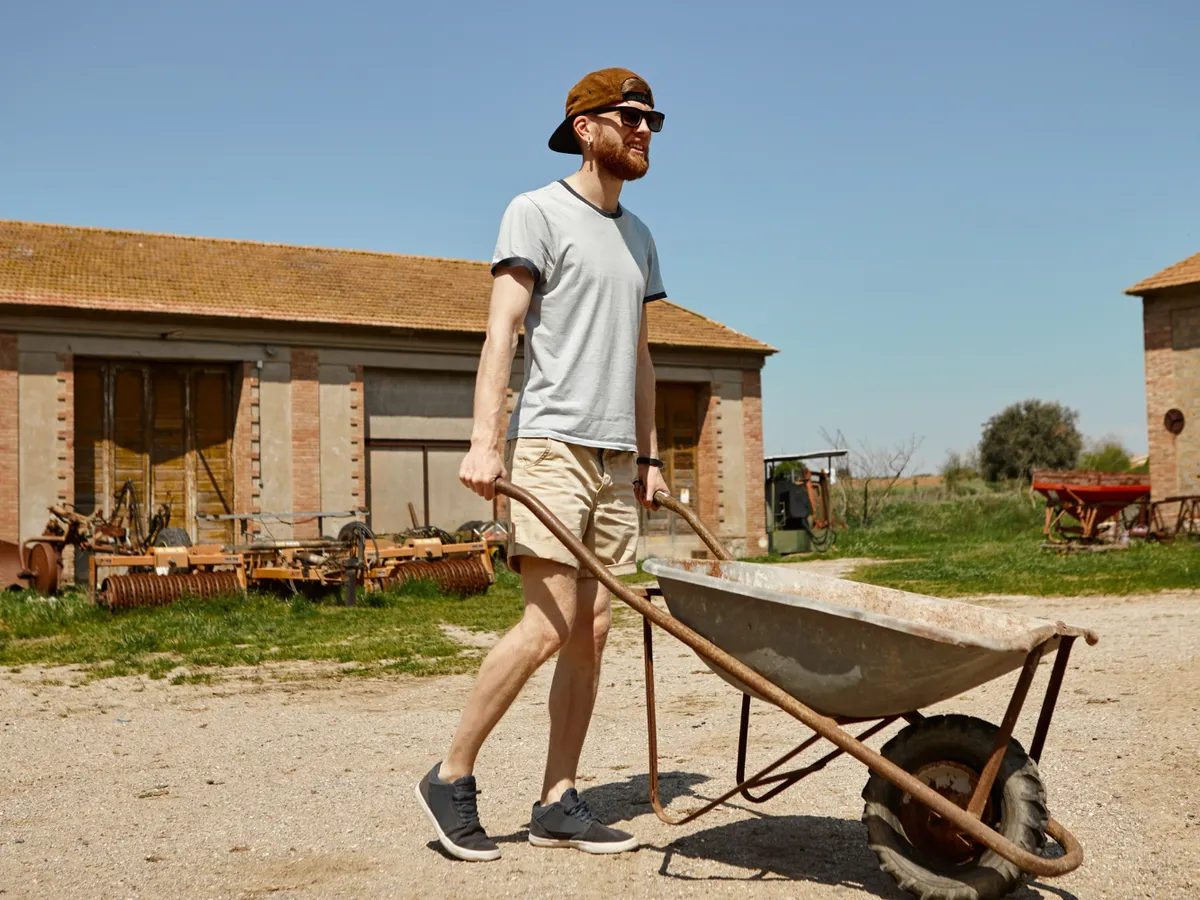 Bărbat care duce o roabă - Foto: Freepik (Imagine cu rol ilustrativ)