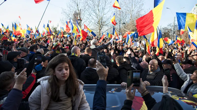 O fetiță a fost urcată pe o mașină de către tatăl ei în ultimul moment, altfel ar fi fost strivită de mulțimea dezlănțuită Foto: Mugur Vărzariu