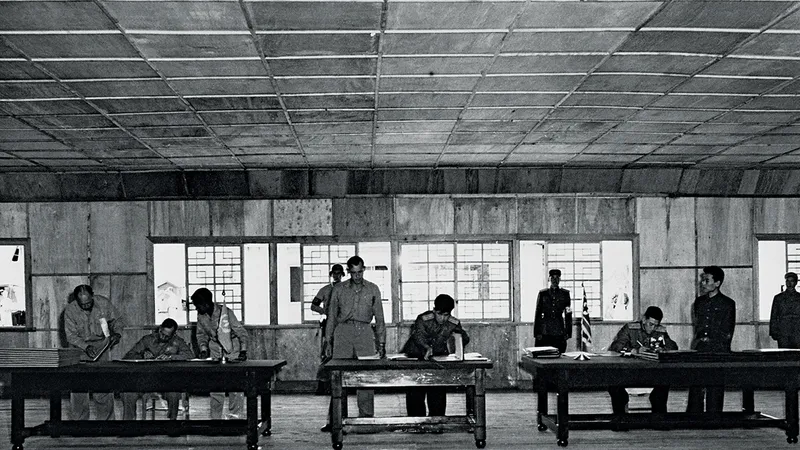 O PACE NEOFICIALĂ Reprezentanții Națiunilor Unite, ai Coreei de Nord și ai Chinei semnează armistițiul de încheiere a Războiului din Coreea, pe 27 iulie 1953 - Foto: AFP/ Getty Images
