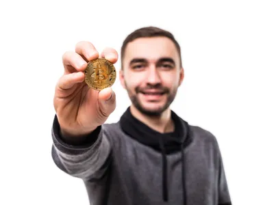 Bărbat care ține o criptomonedă în mână - Foto: Freepik (Imagine cu rol ilustrativ)