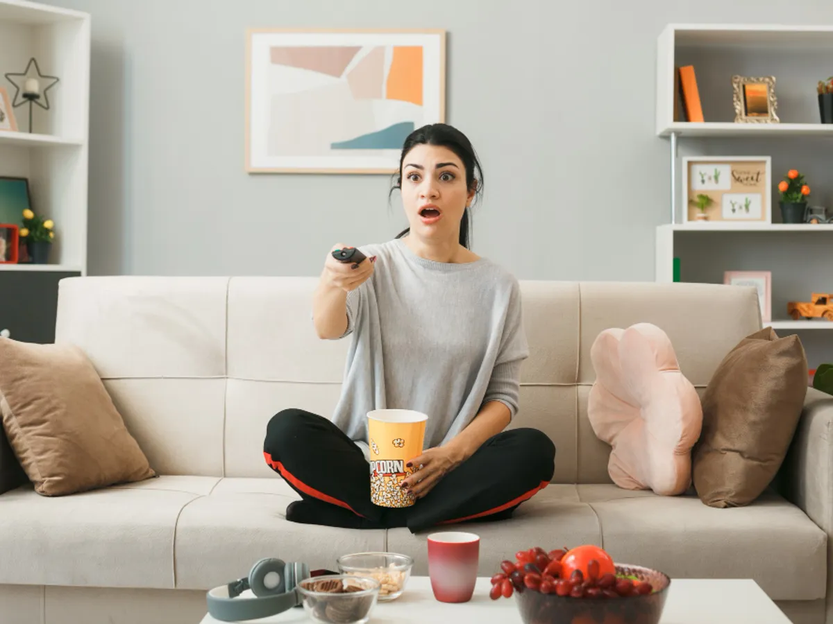 O femeie aprinde televizorul cu telecomanda - Foto: Freepik