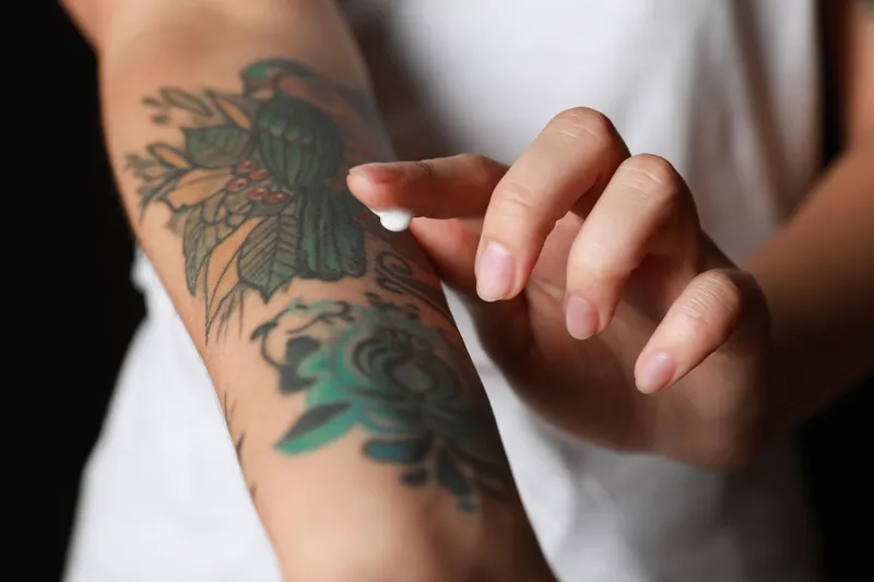 Femeie care se dă cu o cremă pe tatuaj -Foto: Freepik (rol ilustrativ)