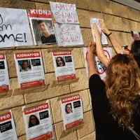 Family members of Israeli hostages kidnapped by Hamas stick their pictures on a wall in Tel Aviv Photo: profimediaimages.ro