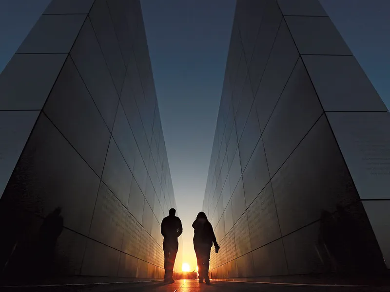 Oamenii merg prin Memorialul Cerului Gol 9/11 din Liberty State Park, New Jersey