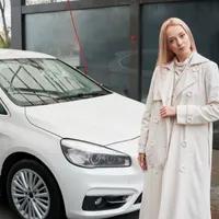 Femeie stând în faţa unei maşini parcate - Foto: Magnific.com/ArtPhoto_studio