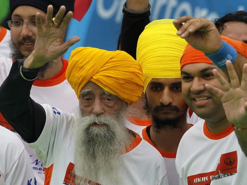 Fauja Singh salută publicul, după ce a trecut linia de sosire în proba de 10 km, la Maratonul de la Hong Kong - Foto: Profimedia Images