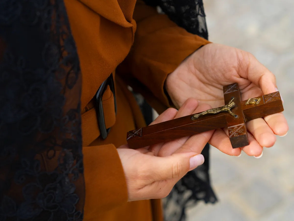 Femeie care ține o cruce în mână - Foto: Freepik (Imagine cu rol ilustrativ)