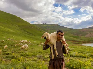 Cioban ţinând pe umeri un miel - Foto: Pexels/Kaan Durmuş (Imagine cu caracter ilustrativ)