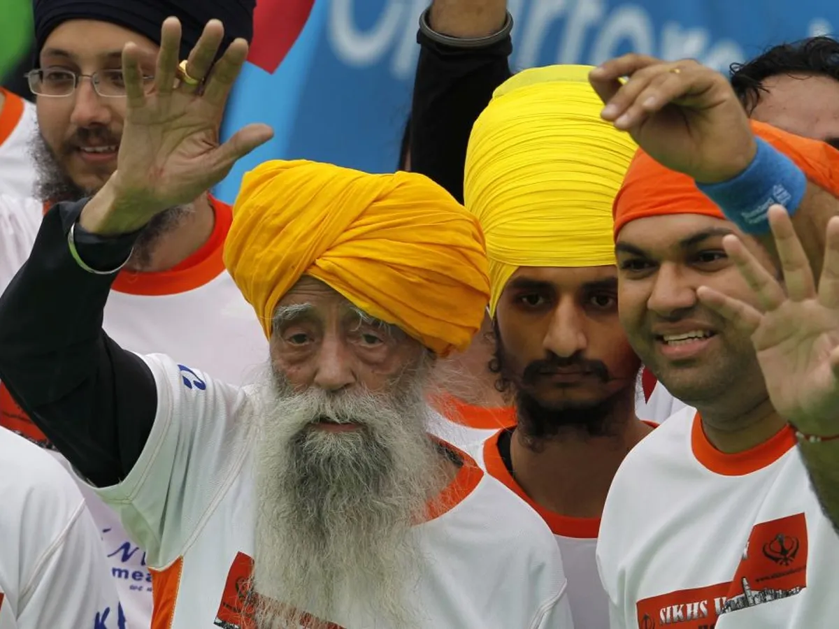 Fauja Singh salută publicul, după ce a trecut linia de sosire în proba de 10 km, la Maratonul de la Hong Kong - Foto: Profimedia Images